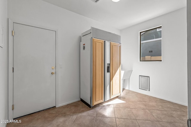 hallway featuring light tile patterned flooring and baseboards