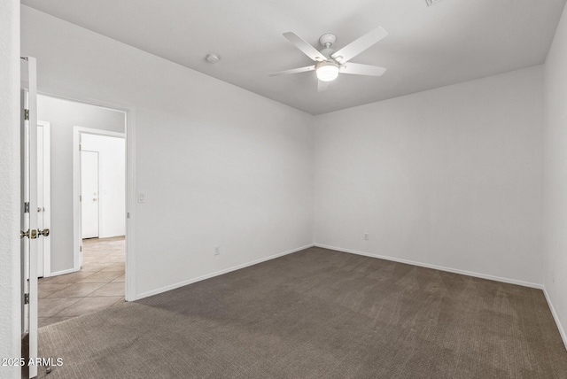 unfurnished room with tile patterned floors, baseboards, ceiling fan, and carpet floors