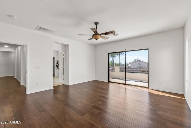 empty room with visible vents, baseboards, dark wood-style floors, and ceiling fan