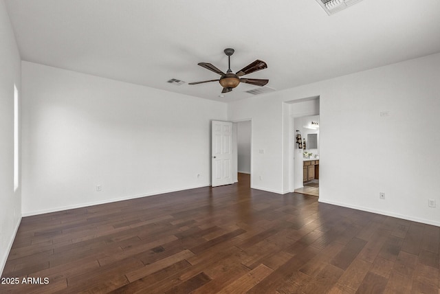 spare room with dark wood finished floors, a ceiling fan, visible vents, and baseboards