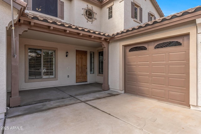 view of front of house with stucco siding, an attached garage, and concrete driveway