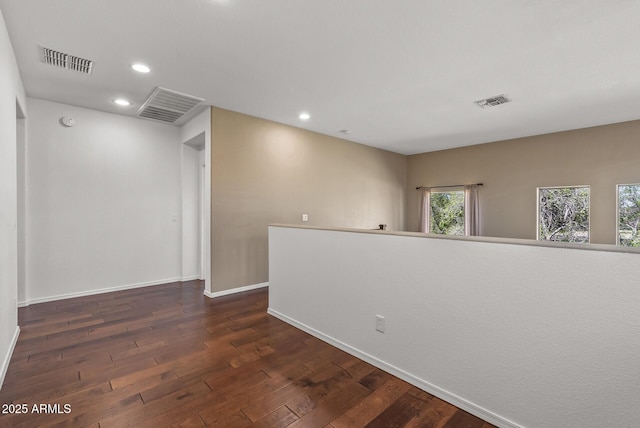 empty room with recessed lighting, visible vents, baseboards, and dark wood-style flooring