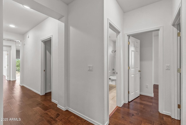 corridor with dark wood-style floors and baseboards