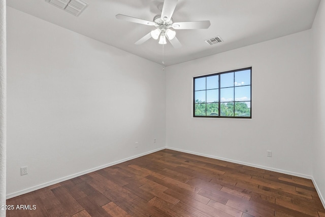 spare room with dark wood-type flooring, baseboards, visible vents, and ceiling fan