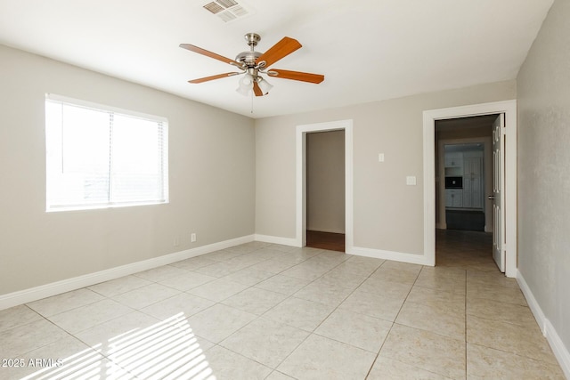 unfurnished bedroom featuring a spacious closet, ceiling fan, light tile patterned floors, and a closet