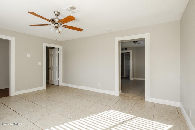 tiled spare room with ceiling fan