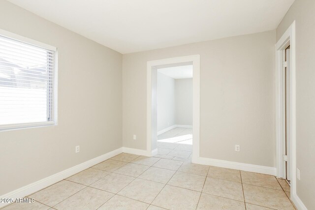 spare room with light tile patterned floors and a wealth of natural light