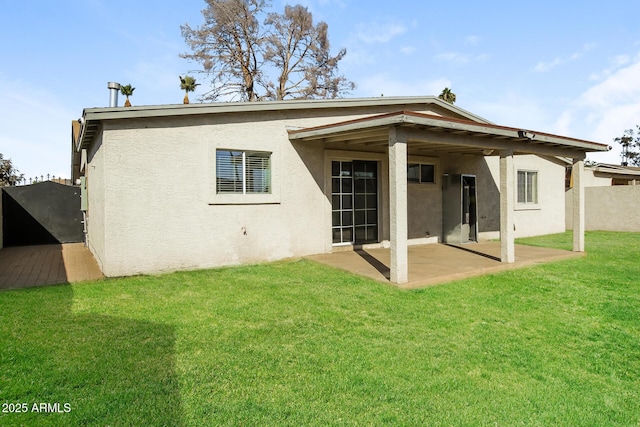 back of house featuring a lawn and a patio