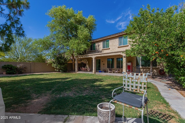 back of property featuring a patio area and a lawn