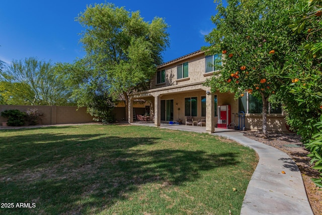 back of house with a patio area and a yard