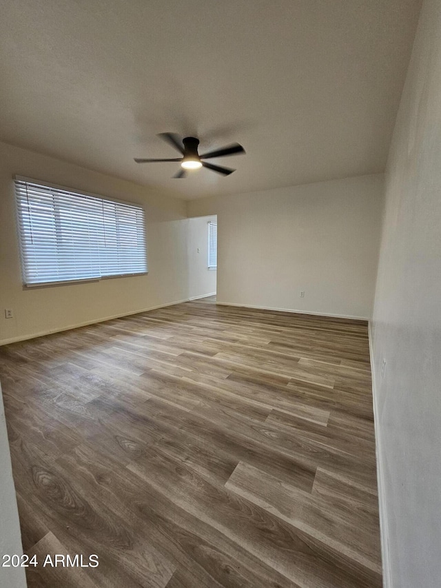 empty room with hardwood / wood-style floors and ceiling fan