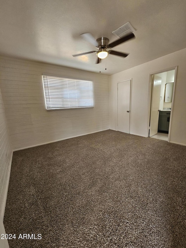 unfurnished bedroom featuring ceiling fan, ensuite bathroom, and carpet