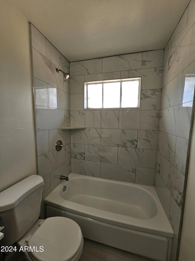 bathroom with tiled shower / bath and toilet