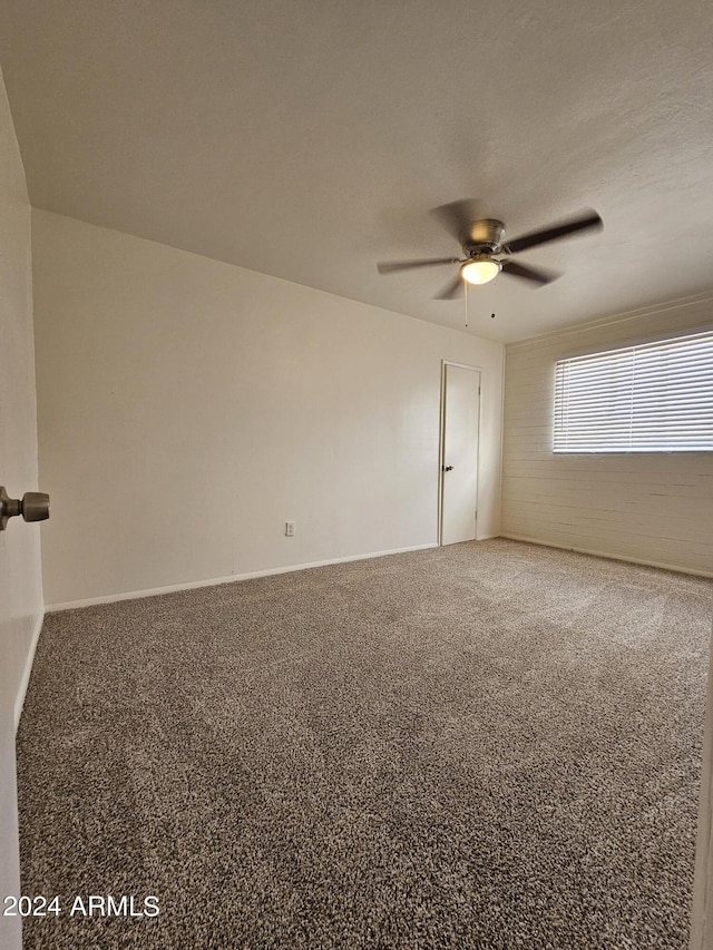 carpeted spare room with ceiling fan