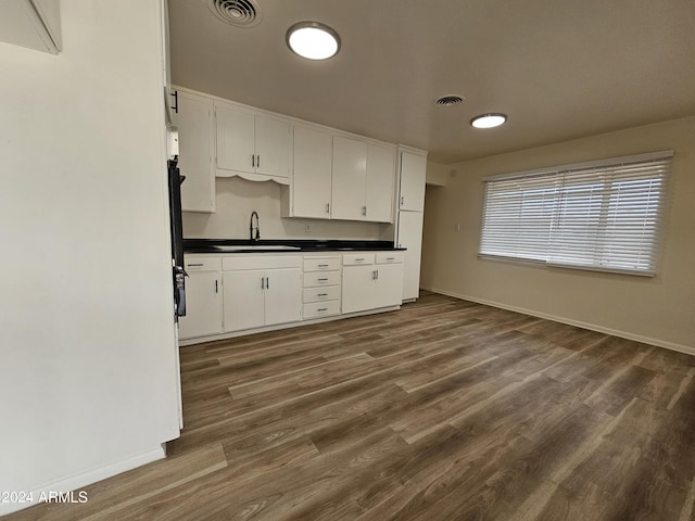 kitchen featuring dark hardwood / wood-style floors, sink, and white cabinets