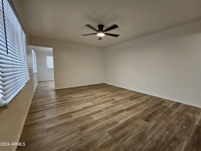 empty room featuring dark wood-type flooring and ceiling fan