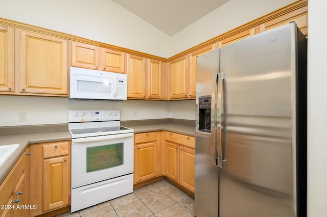 kitchen with light brown cabinetry, light tile patterned floors, white appliances, vaulted ceiling, and light countertops