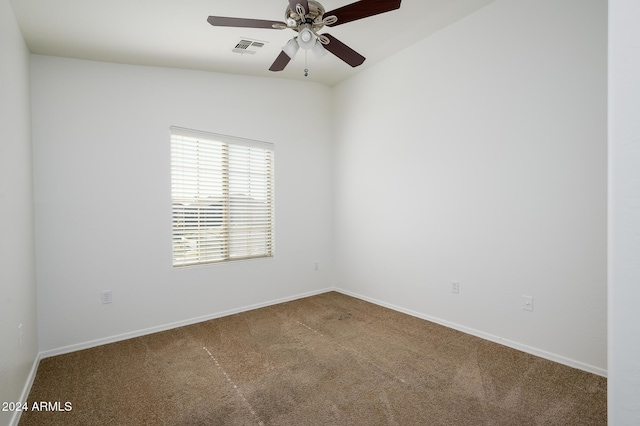 carpeted spare room featuring visible vents, baseboards, and ceiling fan