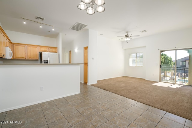 unfurnished living room with tile patterned floors, visible vents, and carpet