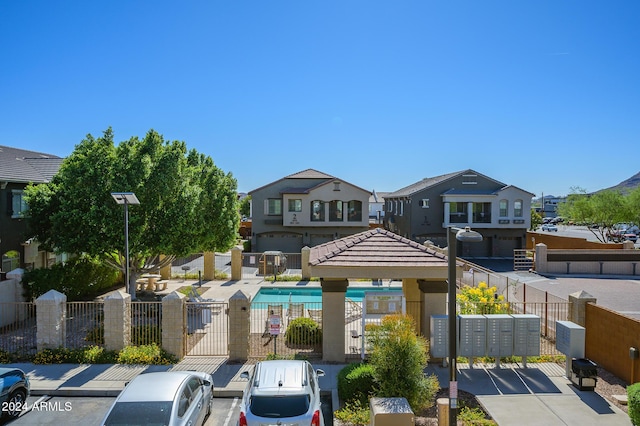 view of front of property featuring uncovered parking, fence, and a residential view