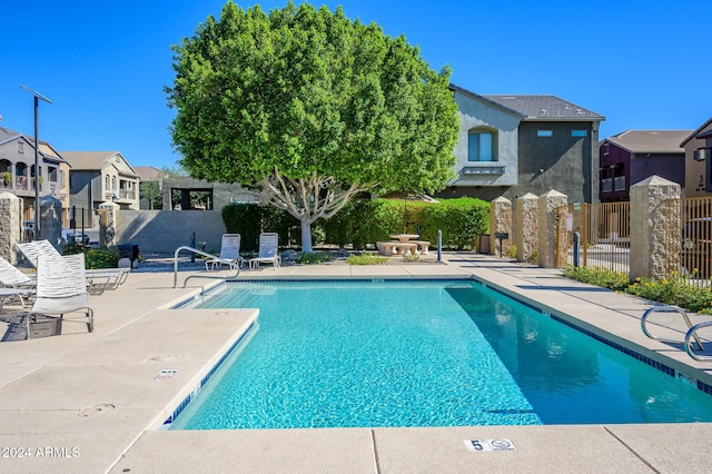 pool featuring a patio, a residential view, and fence