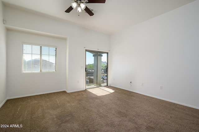 carpeted empty room with a ceiling fan and baseboards