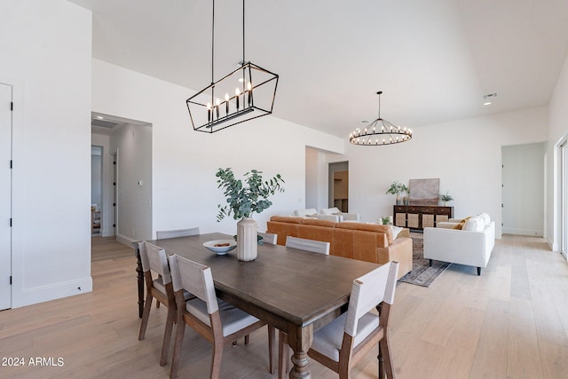 6926 N 177th Pl, Waddell, AZ 85355 - dining area featuring a chandelier, light wood-style flooring, a high ceiling, and baseboards