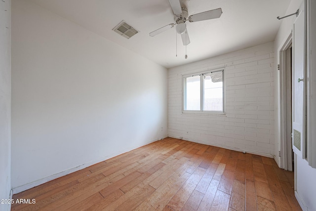1614 S 6th Ave, Phoenix, AZ 85003 - empty room featuring light wood-type flooring, a ceiling fan, and brick wall