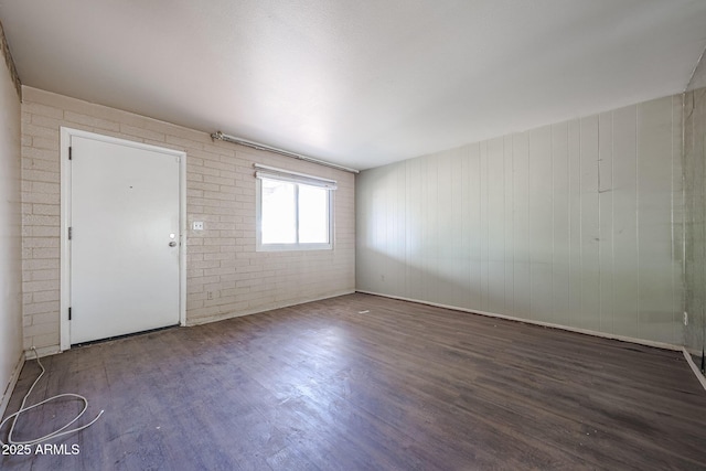 1614 S 6th Ave, Phoenix, AZ 85003 - spare room with wood finished floors and brick wall