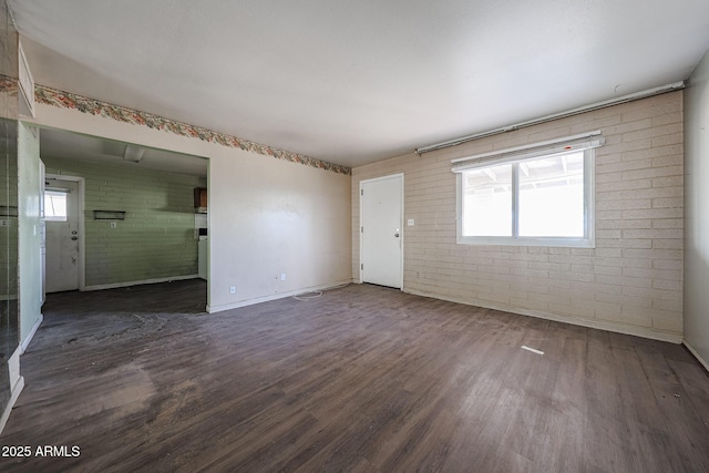1614 S 6th Ave, Phoenix, AZ 85003 - spare room featuring brick wall, wood finished floors, and baseboards