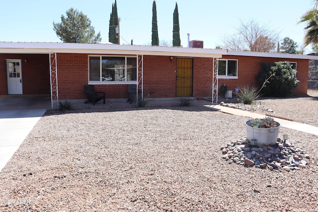 ranch-style house with brick siding, metal roof, and a chimney