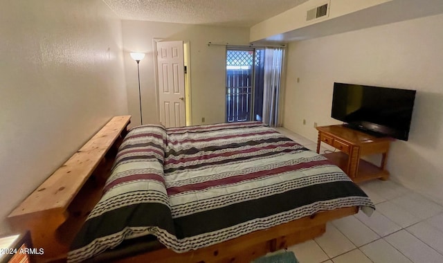 tiled bedroom with a textured ceiling