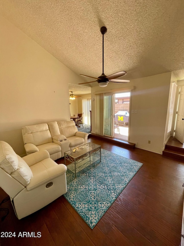 living room with a textured ceiling, ceiling fan, and dark hardwood / wood-style floors