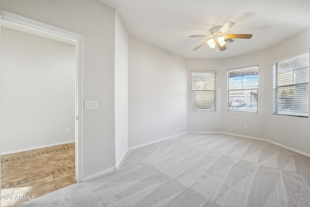 spare room featuring ceiling fan and light carpet