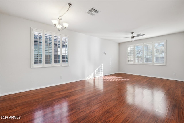 spare room with wood-type flooring and ceiling fan with notable chandelier