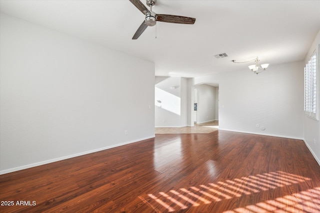 spare room with hardwood / wood-style floors and ceiling fan with notable chandelier