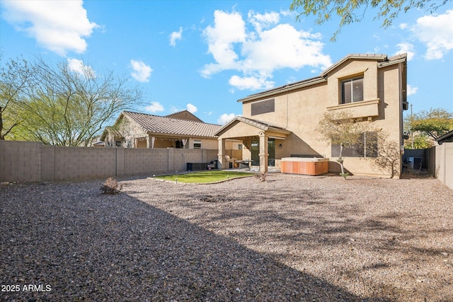 back of property with a patio and a hot tub