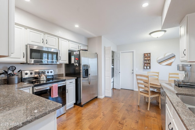 9128 W Kimberly Way, Peoria, AZ 85382 - kitchen with stainless steel appliances, white cabinetry, light wood-type flooring, dark stone counters, and recessed lighting