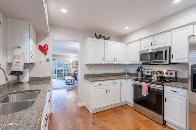 9128 W Kimberly Way, Peoria, AZ 85382 - kitchen with stainless steel appliances, a sink, white cabinetry, light wood-type flooring, and recessed lighting