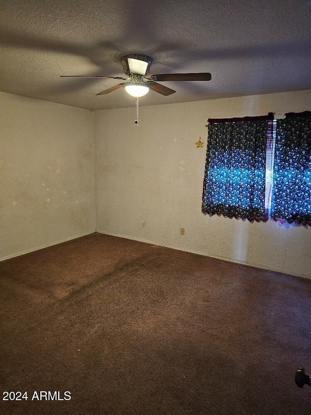 carpeted empty room with ceiling fan and a textured ceiling