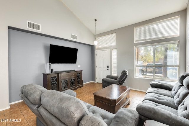 living room featuring high vaulted ceiling and light tile patterned floors