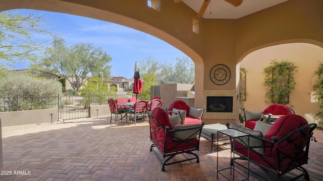 view of patio / terrace featuring an outdoor living space with a fireplace, fence, and outdoor dining space