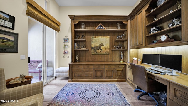 office space with light wood-style floors and built in desk