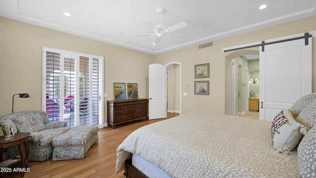 bedroom with arched walkways, wood finished floors, visible vents, and recessed lighting