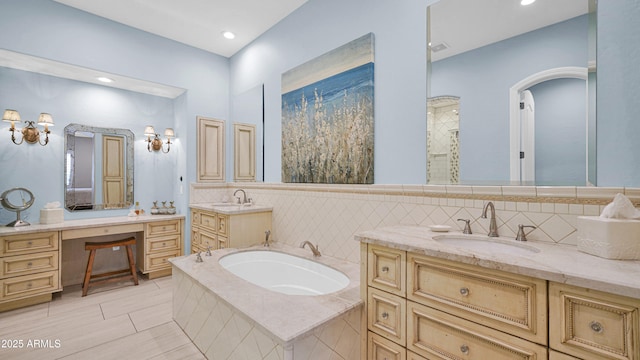 bathroom featuring a garden tub, vanity, and decorative backsplash