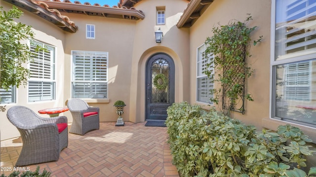 doorway to property featuring a patio area and stucco siding