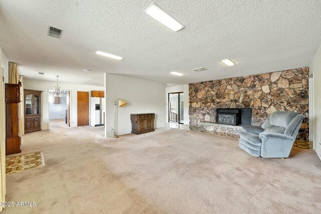2235 W Mendiburo Way, Prescott, AZ 86305 - unfurnished living room with an inviting chandelier, carpet floors, a stone fireplace, and visible vents