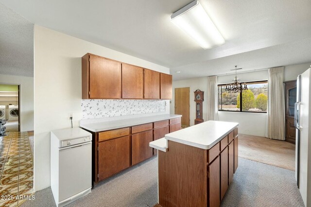 2235 W Mendiburo Way, Prescott, AZ 86305 - kitchen with washer and clothes dryer, light countertops, light carpet, a center island, and decorative backsplash