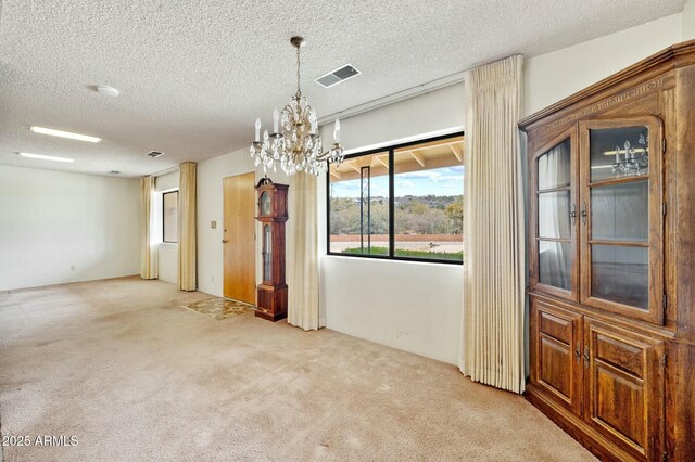 2235 W Mendiburo Way, Prescott, AZ 86305 - unfurnished dining area with a textured ceiling, visible vents, carpet floors, and an inviting chandelier