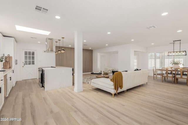 living room featuring wood walls, a notable chandelier, and light wood-type flooring